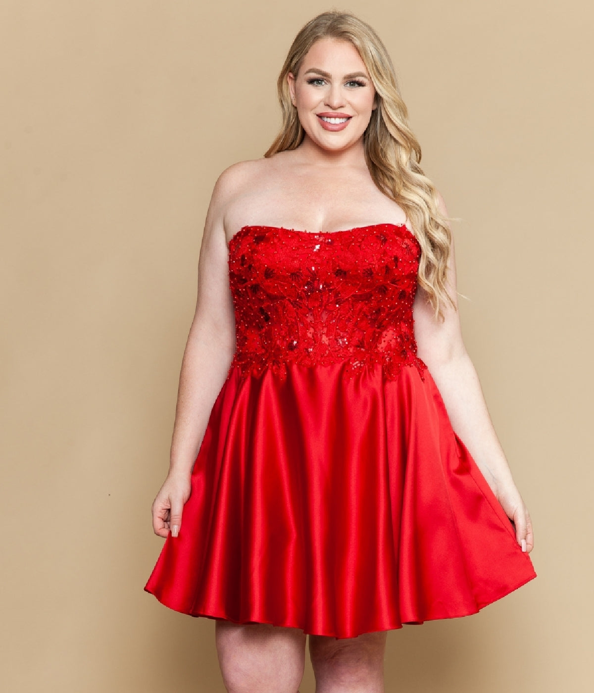 A woman models the Plus-Size Strapless Party Dress: Poly USA W1220, featuring a corset-style bodice and flared satin skirt, standing against a plain beige background.